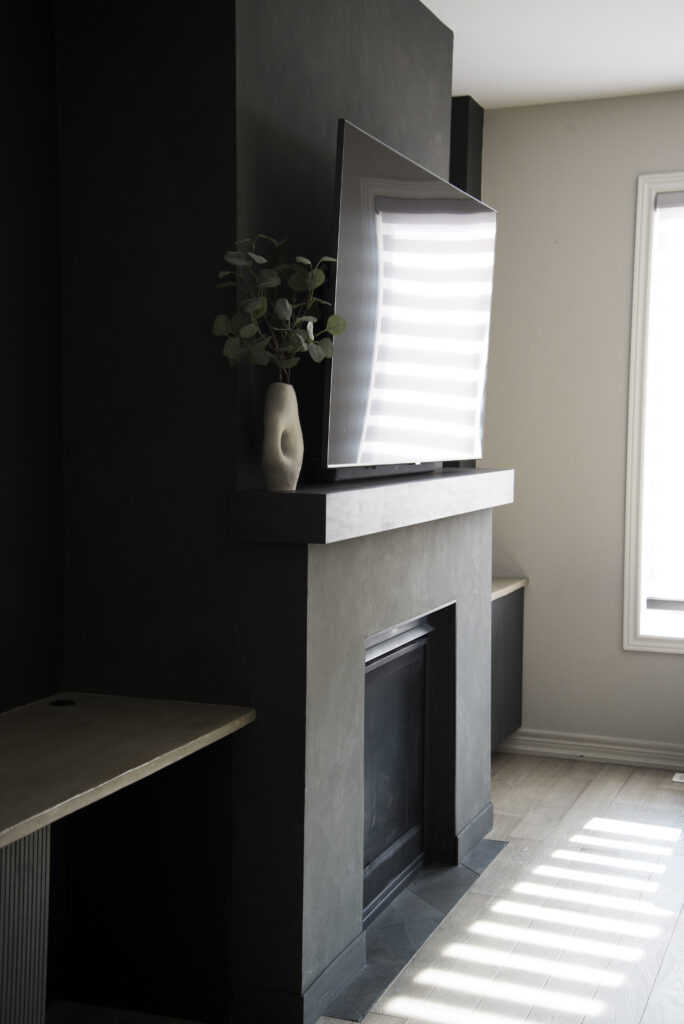 Black Roman Clay fireplace surround and fluted door front built in cabinets with cement countertops